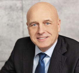 KeithJConnell Photo of Keith in a dark suit and blue tie